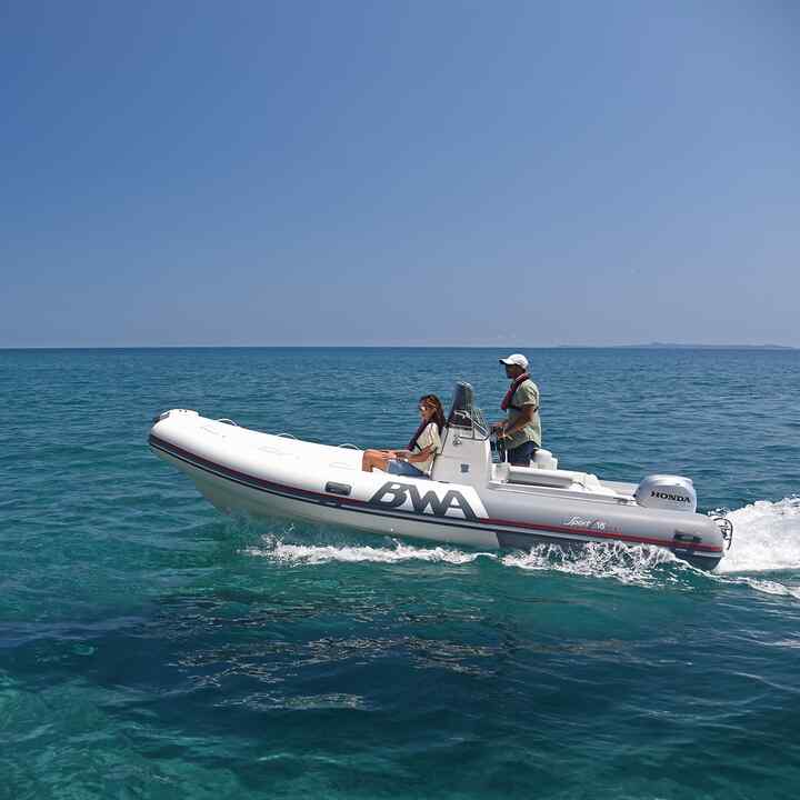 Dvojica naboku stojí oproti člnu Honwave s motorom BF na pobreží.